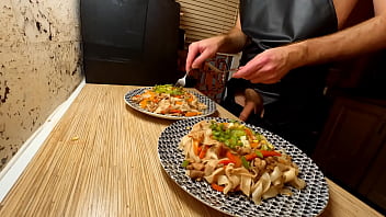 Sexy cooking. Naked gay chef is cooking rice noodle with chicken and vegetables